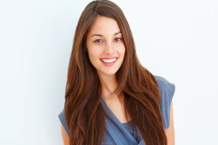 Una giovane ragazza che sorride per mostrare i suoi denti dritti.