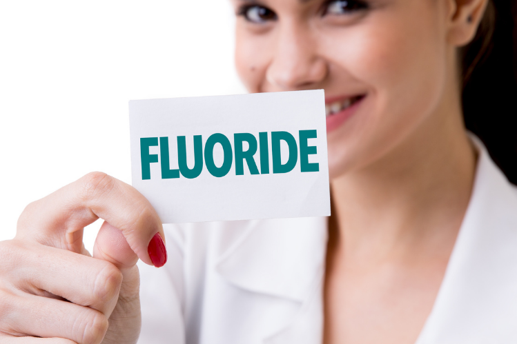 Un medico che tiene in mano una flashcard che dice fluoro